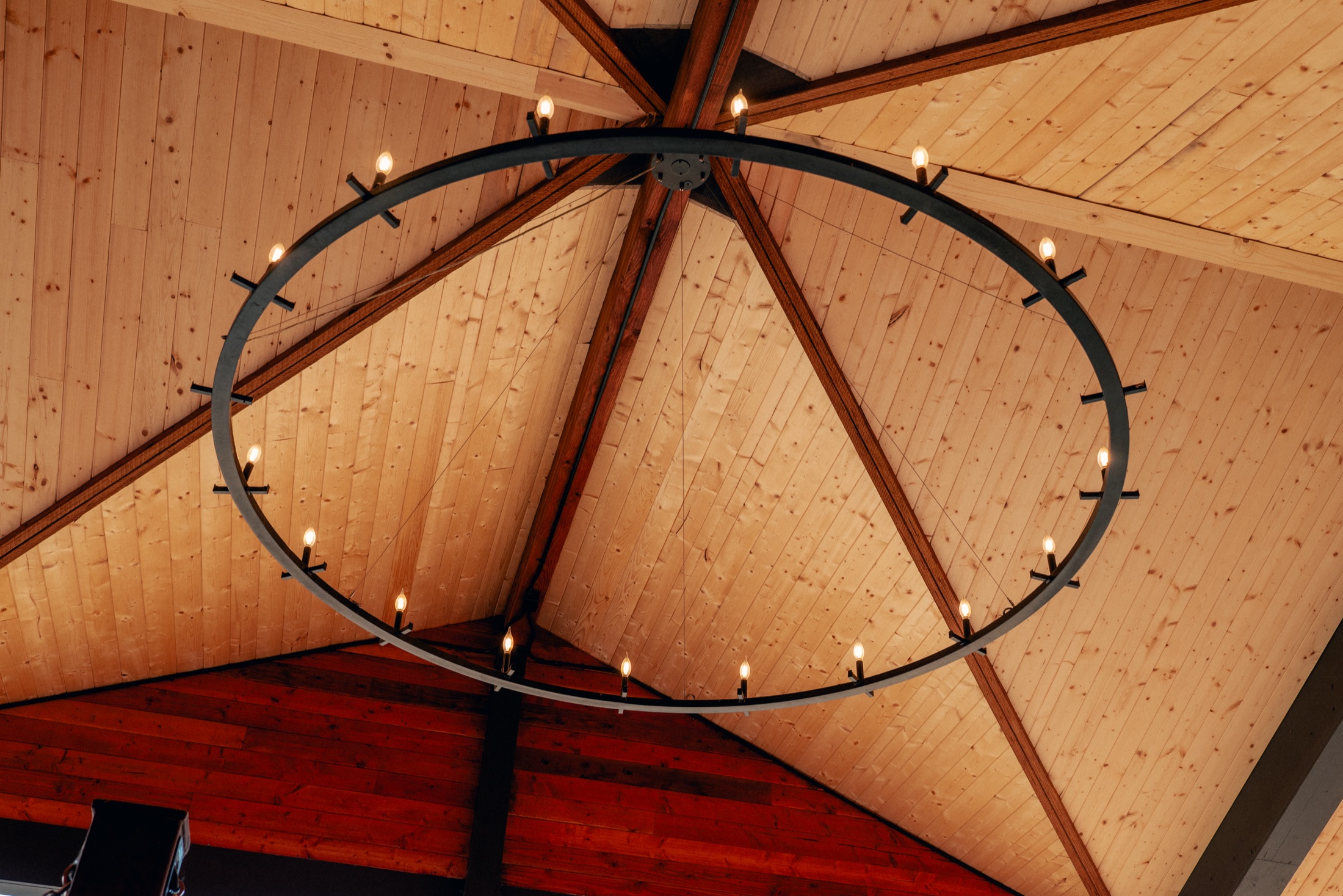 A wrought-iron ring chandelier beneath the timber ceiling of the Equestrian Center