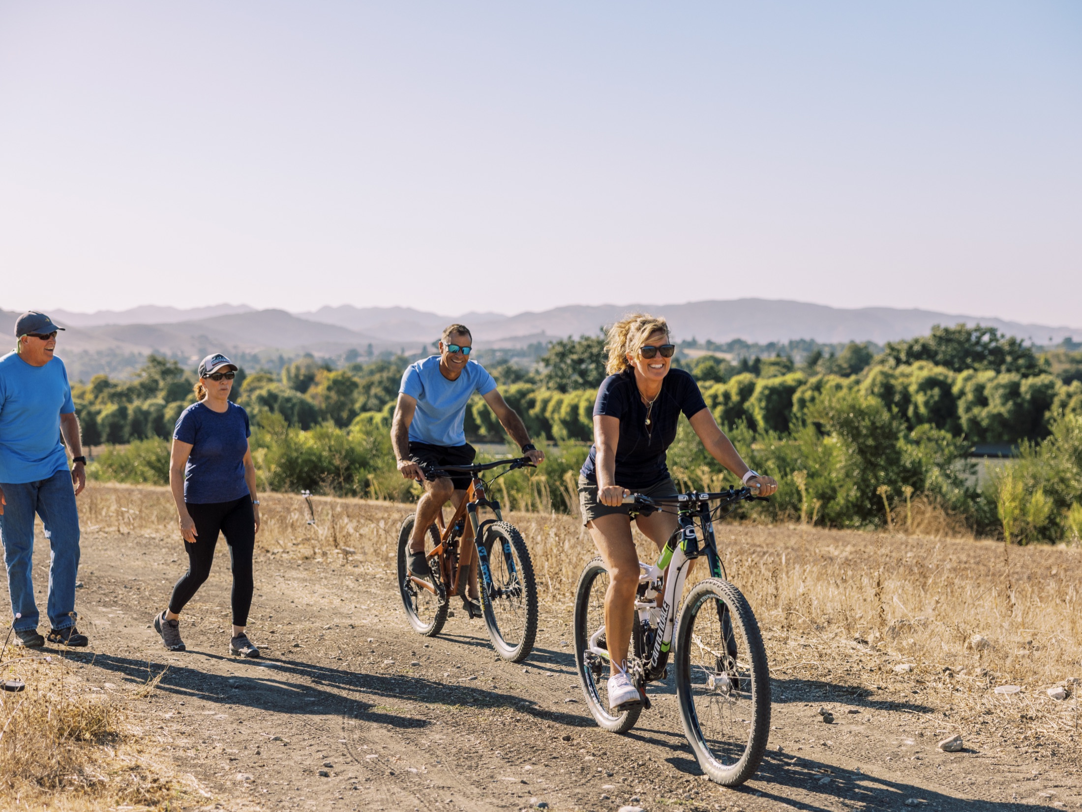 A team biking and walking the estate trails beneath the Edna Valley hills