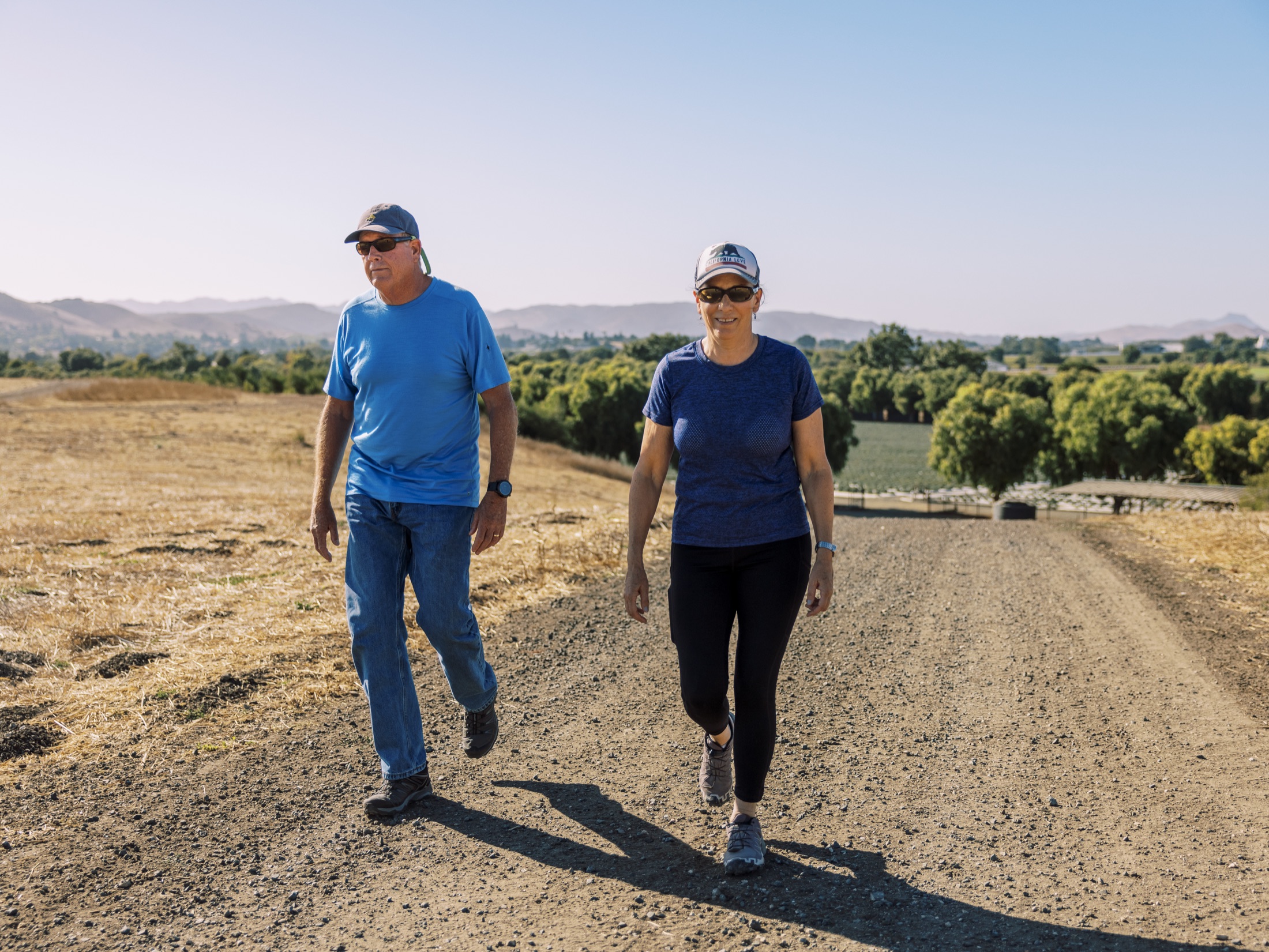 Two guests walking the estate's ranch road in the morning sun