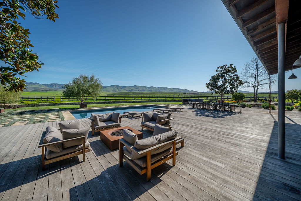 The Vineyard House deck, furnished for lounging with mountain and vineyard views