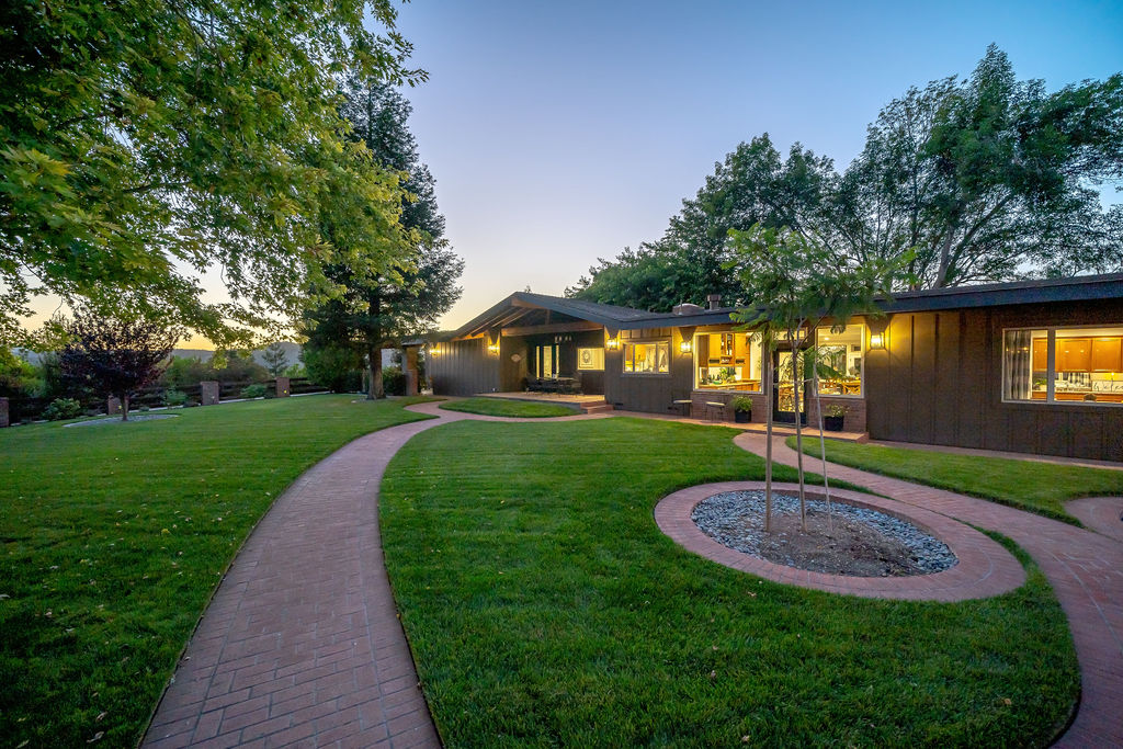 The Ranchhouse lawns and brick paths at twilight, windows warmly lit