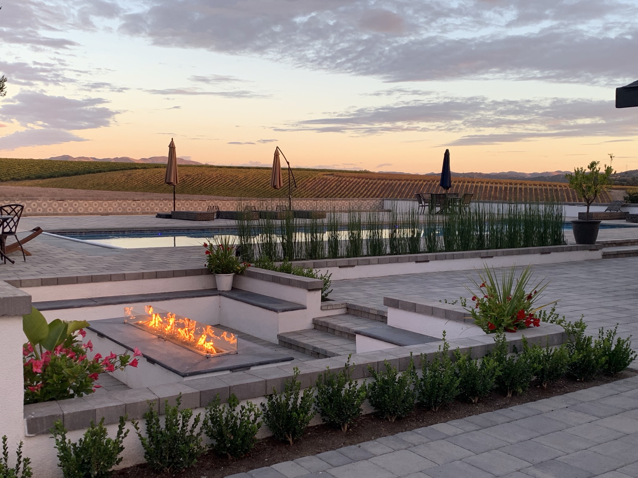 The Villa's sunken fire pit and pool terrace at sunset above the vineyards